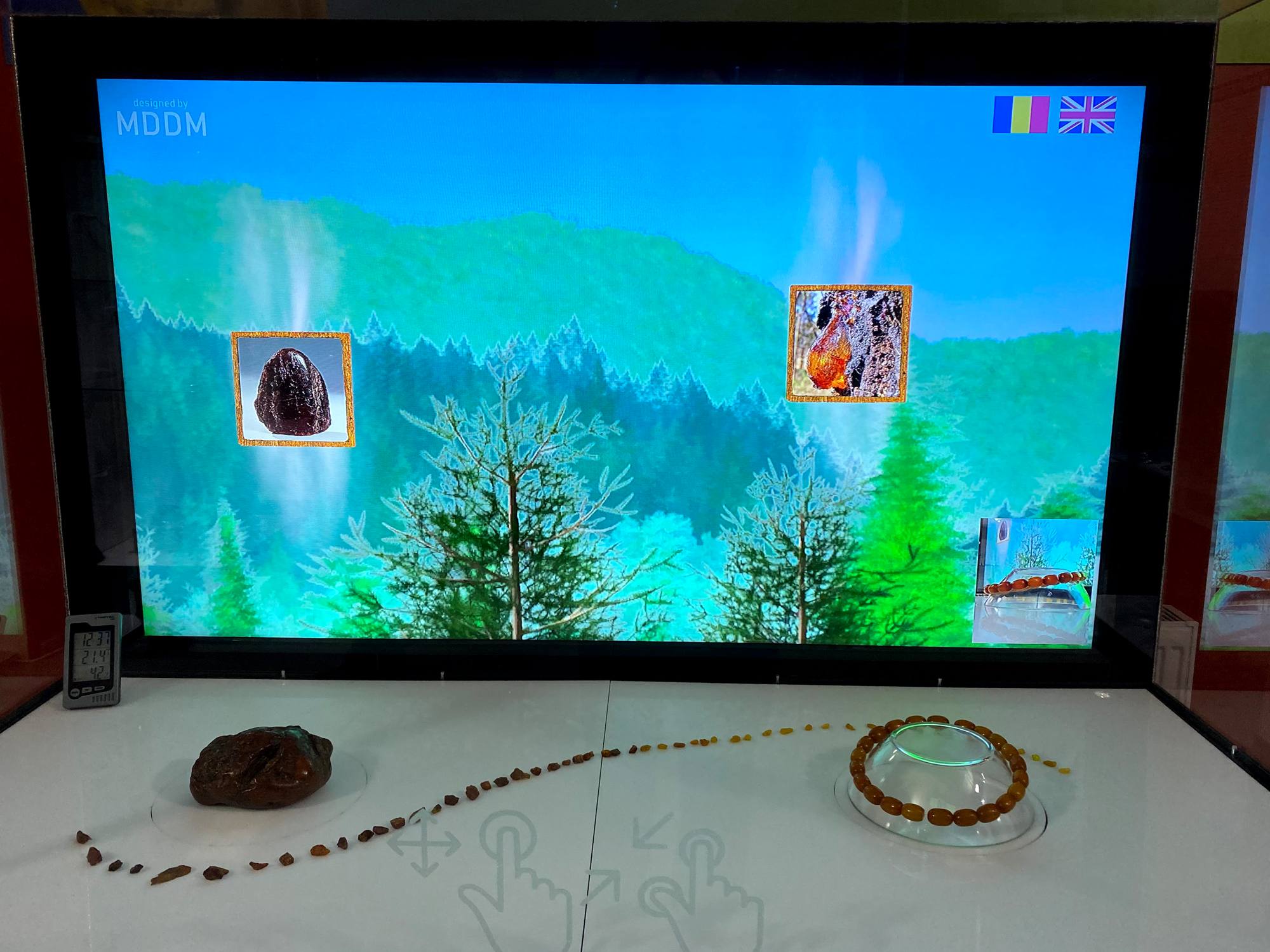 Interfața vitrinei interactive cu un obiect din chihlimbar mărit pe ecran